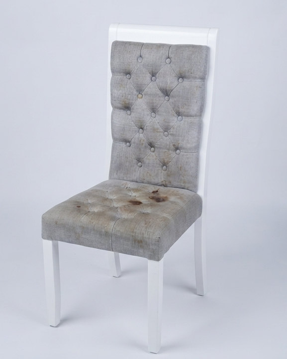 Silla tapizada con manchas oscuras en el asiento antes de la limpieza